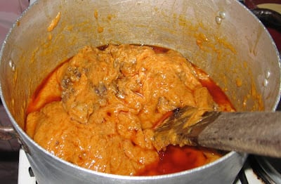 Stirring pot of eko agidi jollof